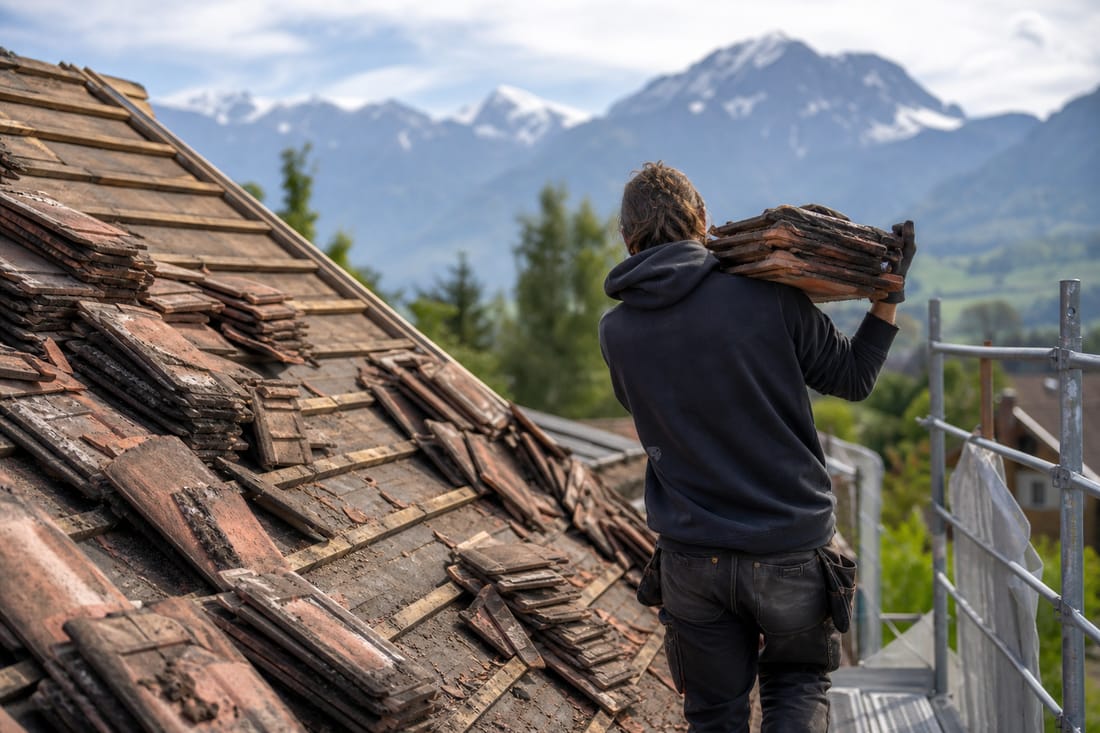 Beispiel: Abdecken einer alten Dachfläche bei einer Sanierung, Dachdecker von hinten